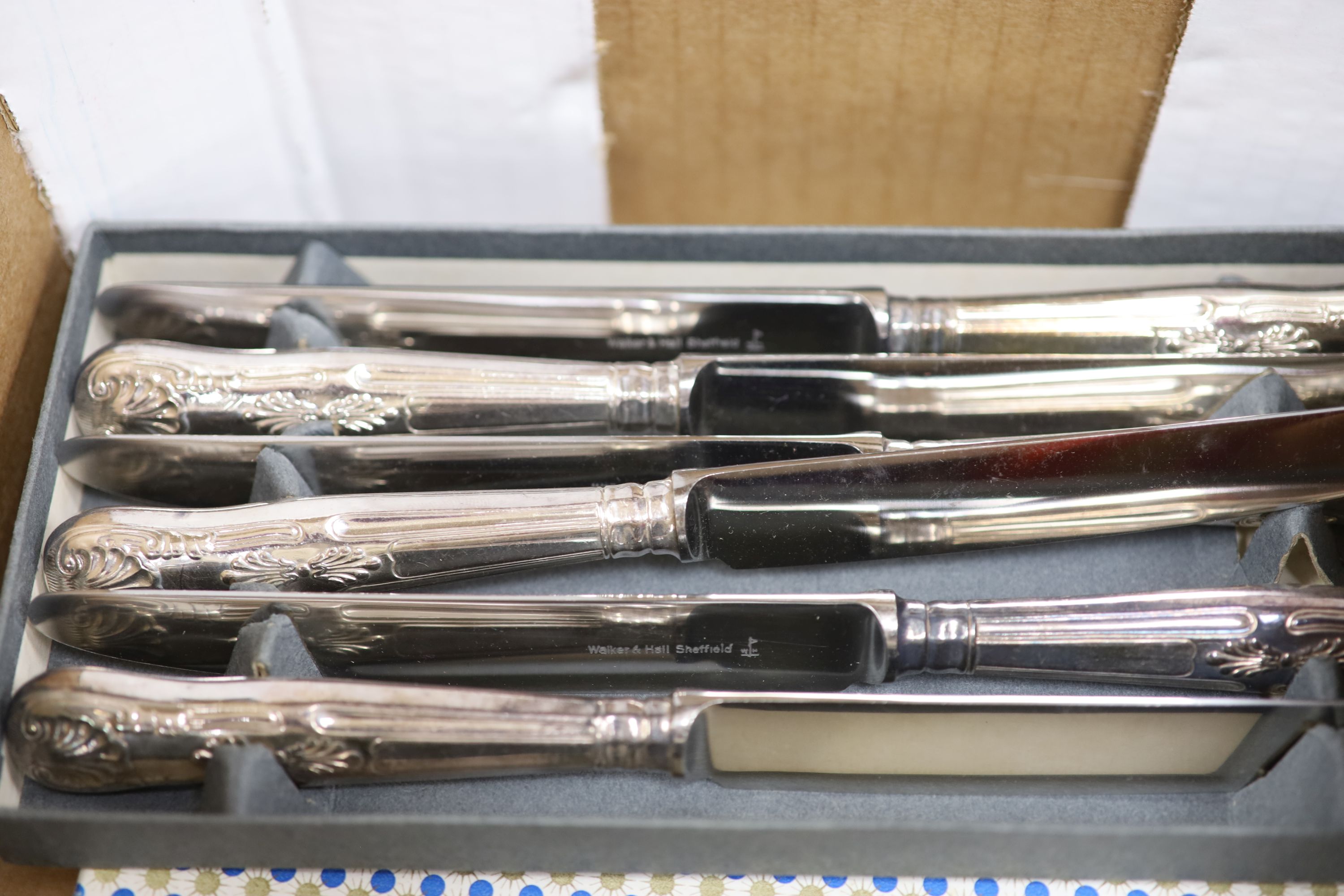 A set of twelve silver plated table and dessert knives(24), two other cased sets of six knives, a three piece carving set and a bottle